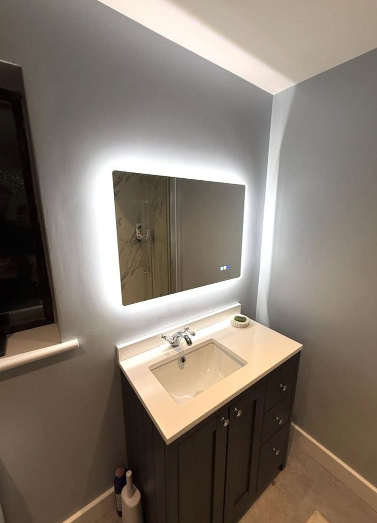 Backlit bathroom mirror above a basin